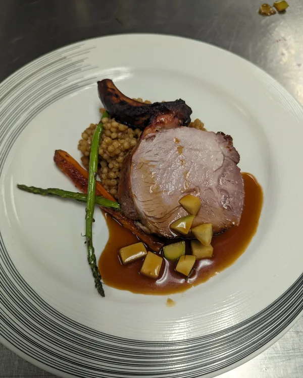 Roast pork loin sliced over lentils with squash, asparagus and a glossy pan jus